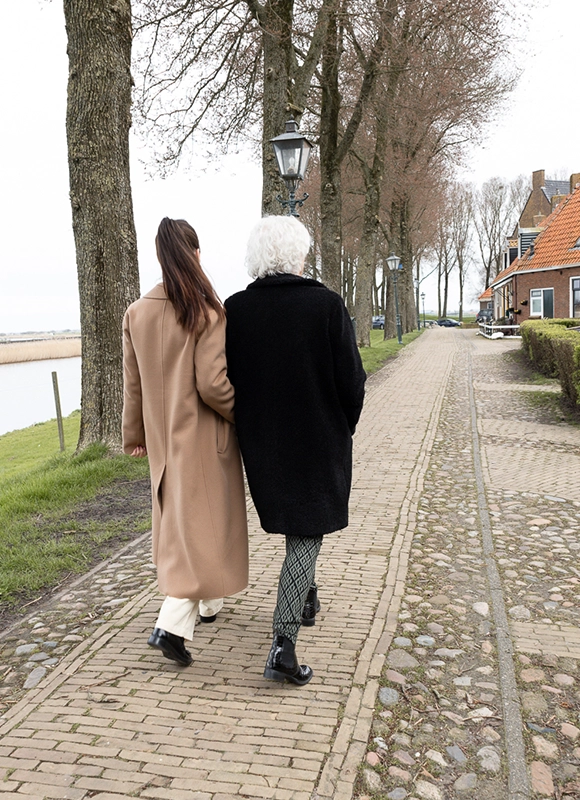 Coach verlies noord coachingsessie Fotografie van mensen die buiten wandelen langs het water omgeven door bomen